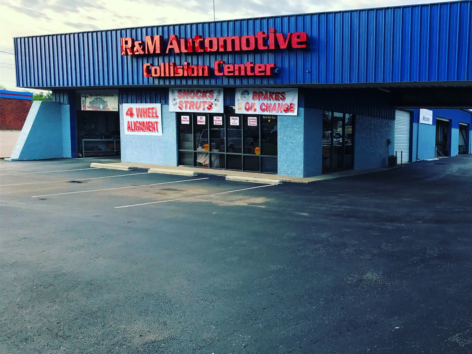 R&M Automotive Collision Center storefront at dusk